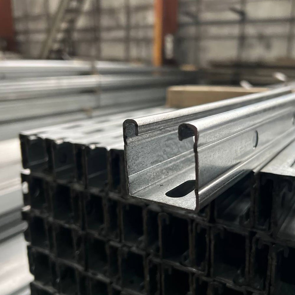 Крупний план оцинкованого перфорованого монтажного гнутого профілю (C-профіль), складований у пачках на складі Loveks-K.